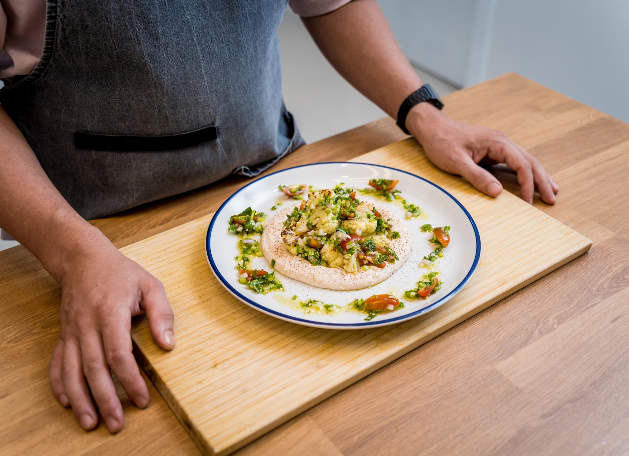 Instructor arranging plated meal on wooden table